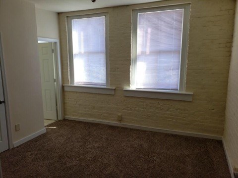 an empty room with two windows and a door